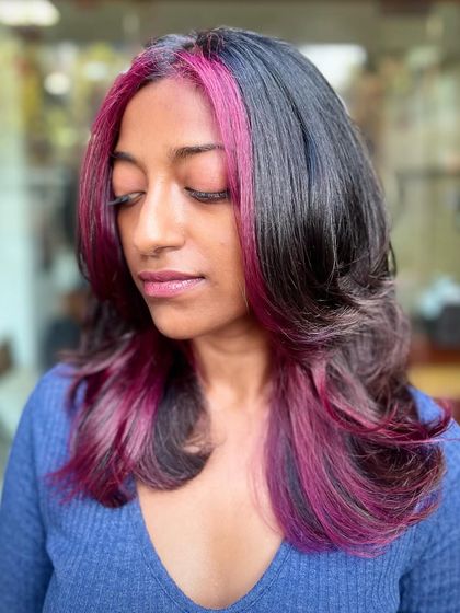 Another look at the purple peekaboo highlights, showing how the color blends seamlessly with her natural hair while still making a statement.