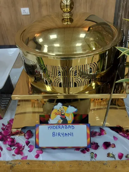 A close-up of a golden chafing dish serving Hyderabadi Biryani, part of my extensive vegetarian menu for weddings and parties.