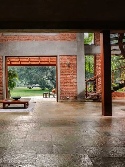 The living area of The Mango House opens directly onto the garden. The use of natural stone flooring and large sliding doors helps to erase the boundary between inside and out, allowing the home to breathe with its environment.