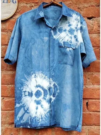An old shirt, beautifully resurrected with natural indigo. The shibori tie-dye technique creates these wonderful floral bursts, turning a simple garment into a piece of wearable art.