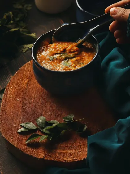 Food is full of emotion and tradition. For this shot of Daleem, a dish close to my heart, I used a moody, dark style with rich textures to create a feeling of warmth and comfort. Adding my own hand shows the human connection I believe every meal has.