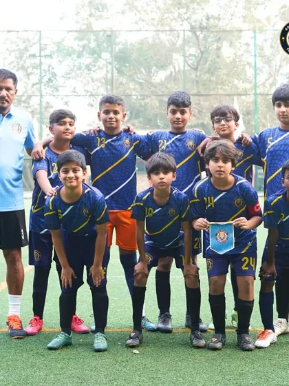 The U-13 team stands united with their coach before a match at The Winter Cup in Mumbai. Posing for a team photo is part of the pre-game ritual that builds unity and focus.