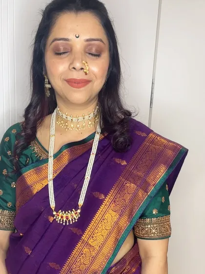 My client Anita celebrating Gauri Ganpati. I created this classic look with a pearl choker, a traditional nath, and makeup that complements her beautiful purple Paithani saree.
