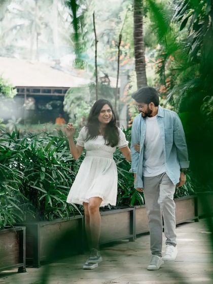A candid photo of a couple walking and talking in a garden setting. The natural interaction makes for a genuine and heartwarming pre-wedding picture.