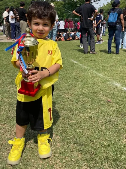 A young player proudly holding a trophy. We redefine the training experience to unlock each player's full potential.