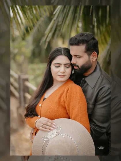 An intimate close-up of the couple in a warm embrace, surrounded by palm trees, capturing a tender and romantic moment.