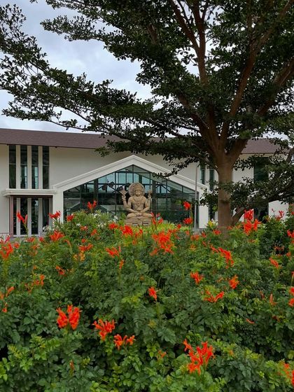 Lord Dhanvantari framed by blooming flowers. He holds the pot of nectar, representing the gift of holistic well-being that we strive to share with every guest.