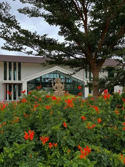 Lord Dhanvantari framed by blooming flowers. He holds the pot of nectar, representing the gift of holistic well-being that we strive to share with every guest.