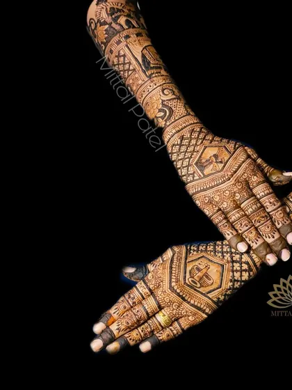 An artistic shot of a bridal back-hand design against a black background, highlighting the intricate patterns.