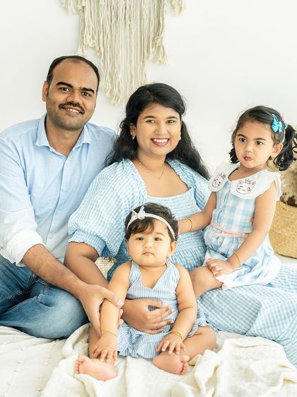 A beautiful portrait of a family of four. The coordinated blue outfits and relaxed poses create a sense of harmony and togetherness in this classic family photo.