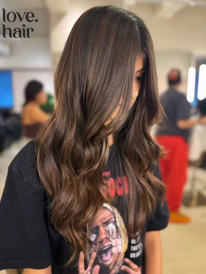 A side view of the golden brown balayage, showing how the color adds dimension and frames the face.