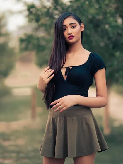 A standing portrait that shows off the full outfit against the beautiful, soft-focus background of the park.
