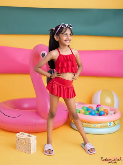 This little girl is ready for the runway in her cute red swimsuit. The summer theme lets kids show off their confident and sassy sides.
