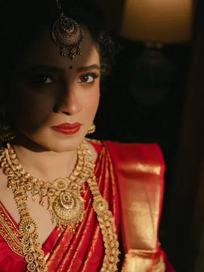 I love creating dramatic and soulful portraits. For this South Indian bridal look, the interplay of light and shadow highlights the rich temple jewellery and the deep red of her Kanjivaram saree. The makeup remains elegant and defined, proving that bold tradition can be achieved with a minimal touch.