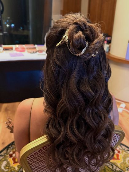 A close-up of the half-up twisted bun with a gold leaf accessory, perfect for a beach wedding or welcome party.