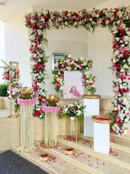 A beautiful setup on the steps of the venue, with a floral arch and traditional elements creating a perfect photo opportunity and welcome area.