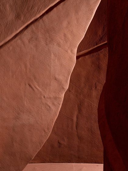 An abstract detail shot of the 'Terra' installation, focusing on the interplay of light, shadow, and form. The image becomes a study in texture and subtle color shifts.