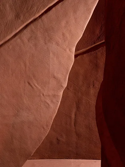 An abstract detail shot of the 'Terra' installation, focusing on the interplay of light, shadow, and form. The image becomes a study in texture and subtle color shifts.