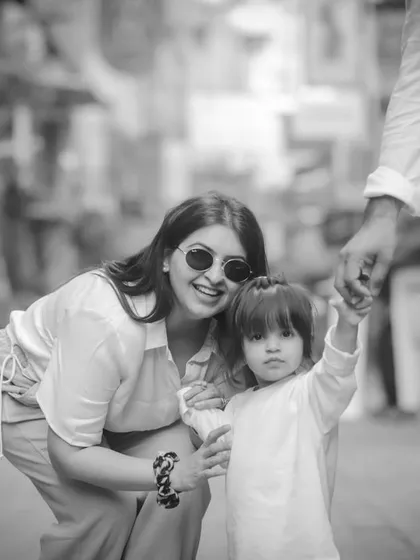 A mother and child sharing a moment on a city street, captured in a candid, documentary-style black and white.