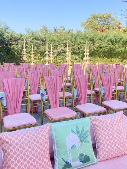 The guest seating for the morning wedding, with pink drapes on the chairs and cones of petals for the flower shower.