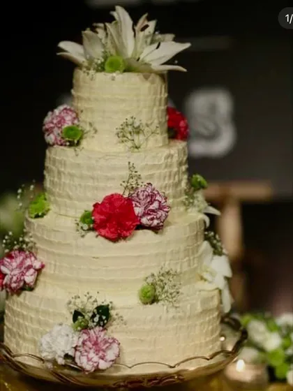This four-tiered rustic wedding cake with textured buttercream and fresh flowers is a testament to our elegant and delicious approach. We believe in the beauty of natural ingredients and skilled craftsmanship.