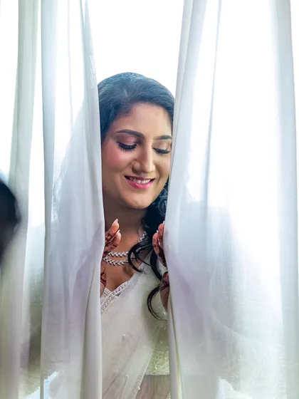 A candid, dreamy shot of the bride, highlighting the soft pink tones on her eyes and her radiant smile.