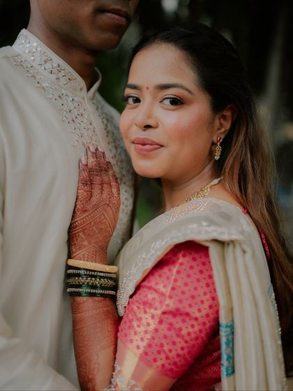 A beautiful portrait of the bride-to-be, her hand resting on her partner's chest. Her calm expression and the details of her henna and traditional bangles are the focus of this intimate shot.