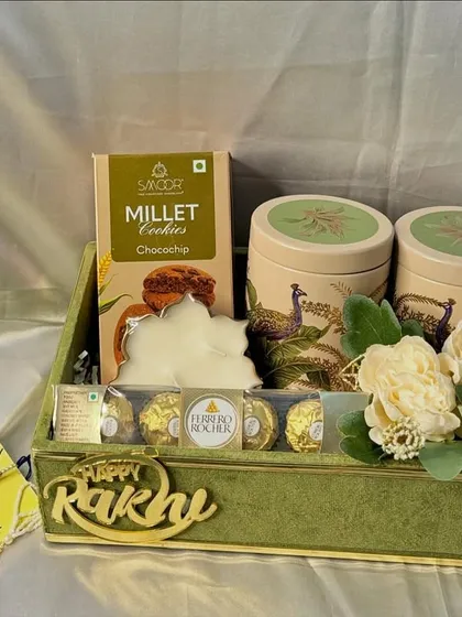 Our peacock-themed Rakhi hamper is perfect for your bhaiya and bhabhi. It includes jars of almonds and makhana, Ferrero Rocher chocolates, and a beautiful candle.