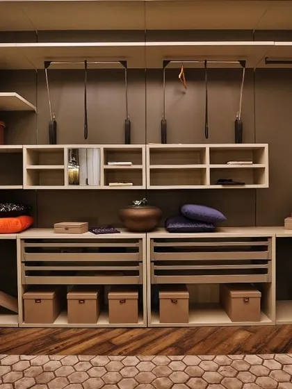 This contemporary walk-in wardrobe showcases a sophisticated material combination. The matte lacquer finish provides a neutral backdrop, while drawers clad in deep blue leather add a touch of bespoke luxury and personality to the space.