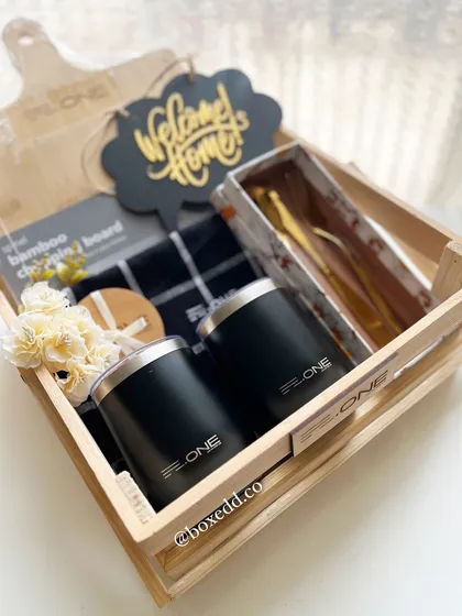 A closer look at the 'Welcome Home' gift crate for real estate clients. It includes a custom-branded chopping board, engraved tumblers, and gold-plated cutlery.