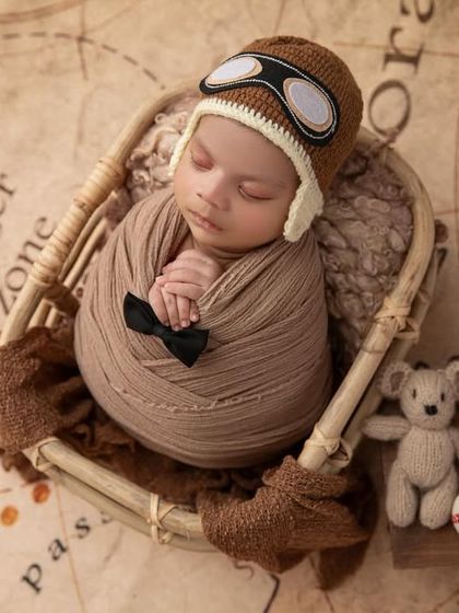 A top down view of the complete aviator setup, showing the baby perfectly centered in the basket, ready for a dreamy adventure. This is a popular theme for baby boy photoshoots.