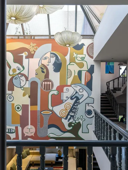 The mural as seen from the side, demonstrating how the artwork wraps around the space and interacts with the staircase and upper landing.