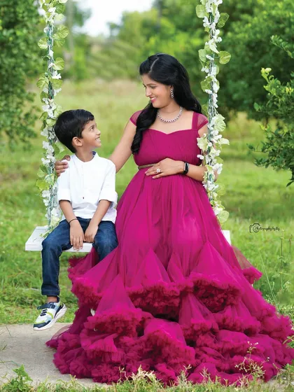A sweet family portrait on our floral swing. The older son sits beside his mother, sharing a special moment.