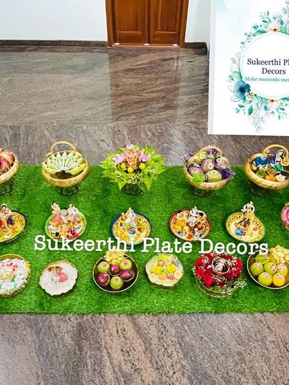 This engagement platter setup in Karumathampatti features a mix of brass and decorated plates. The variety of dolls and arrangements creates a visually interesting display.
