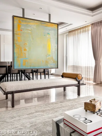 On the other side of the partition, a vibrant abstract painting offers a completely different mood, creating a dynamic dialogue between the two connected spaces.