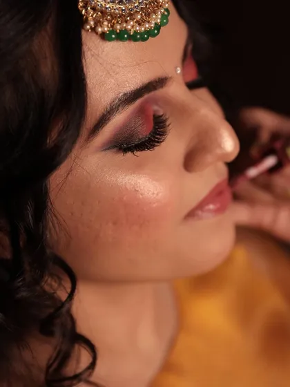 A close-up of the makeup process for Chinmayi's mehendi. We created a beautiful smokey eye with hints of red and a glossy nude lip.
