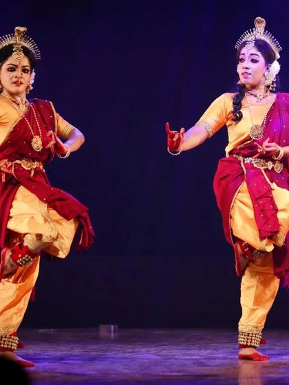 Two dancers in perfect sync during a performance of "Shrishti Stithi Laya". Their coordinated movements and expressions are a result of dedicated practice and a deep understanding of the art form.