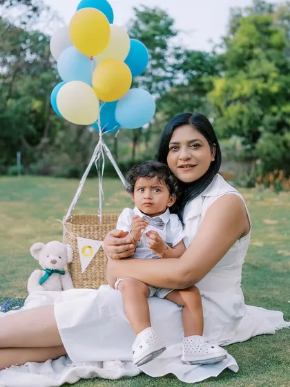 A mother and son sitting on the grass during his first birthday shoot, a sweet and simple portrait.