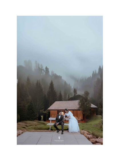A breathtaking, moody shot of the couple at a scenic, foggy mountain location for their reception shoot.