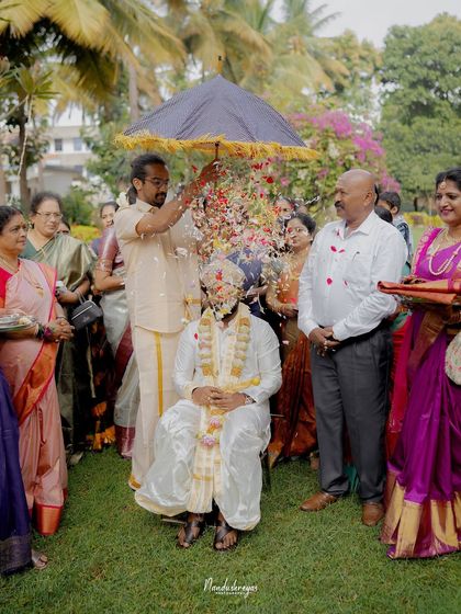 The groom's grand entrance, showered with petals by his family. This photograph captures the celebratory spirit and traditional customs of a South Indian wedding.