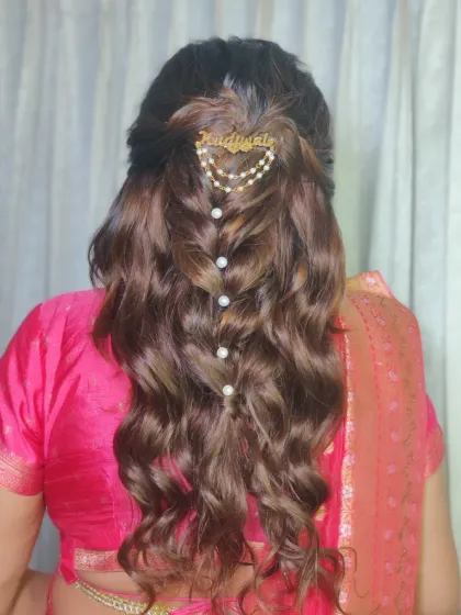 A modern take on a half up, half down hairstyle for Swati's Gujarati look. The soft curls are accented with a personalized hair accessory.