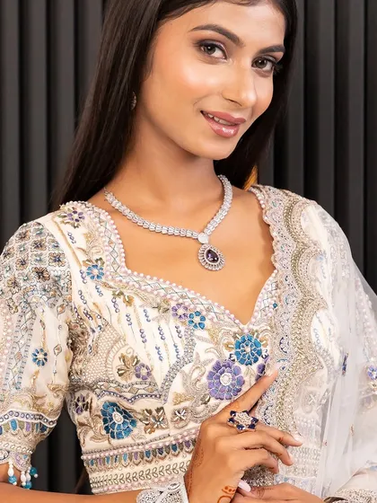 A close-up on the detailed blouse and delicate jewellery paired with the ivory lehenga. I help you style the complete look so you feel confident and beautiful.