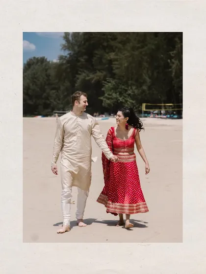 A walk to remember. An Indian bride and a groom in western attire walk hand-in-hand on the sandy shores of Thailand, a beautiful symbol of two cultures uniting.