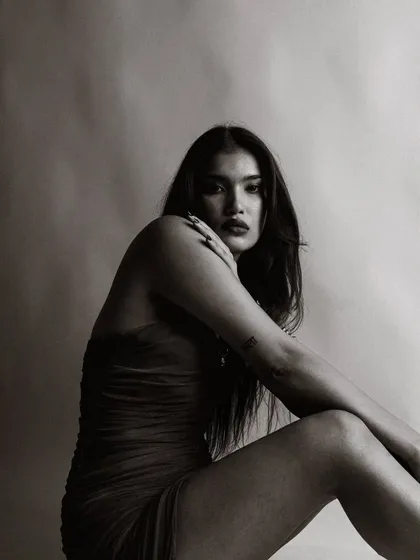 A close-up black and white portrait that is both intense and intimate. The focus is entirely on her captivating gaze.
