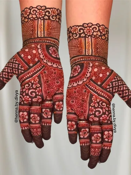 This dense Indian mehendi design covers the entire palm with a variety of traditional patterns. The mix of bold lines and fine details creates a rich and textured look.