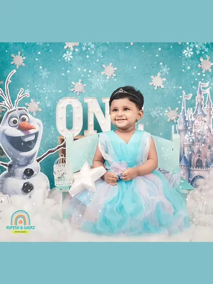 Our little princess enjoying her 'Frozen' wonderland. The themed backdrop and props create a magical setting for a first birthday.