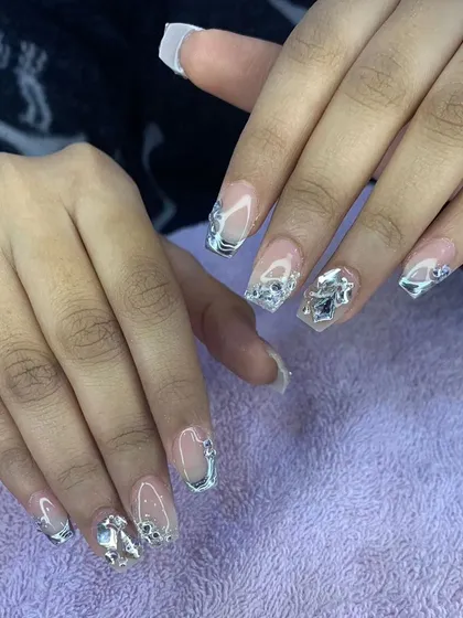 A stunning set of square nails with silver chrome accents and large, 3D silver embellishments.