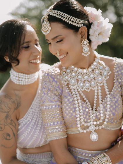 A sweet, smiling moment between the bride and her sister or friend. The shared joy and affection are beautifully captured in this candid shot.