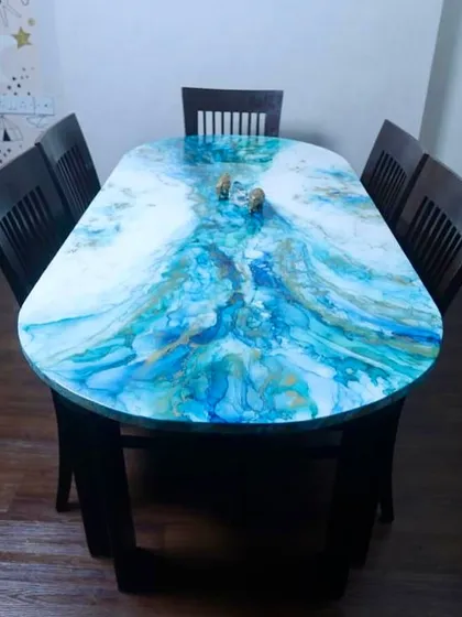 An old dining table I upcycled with a swirling blue and gold alcohol ink and resin design, turning it into a functional piece of abstract art.