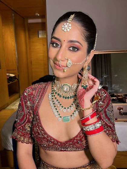 Adjusting her earring, the bride looks effortlessly beautiful. This look is perfect for a bride who wants a modern yet traditional feel.